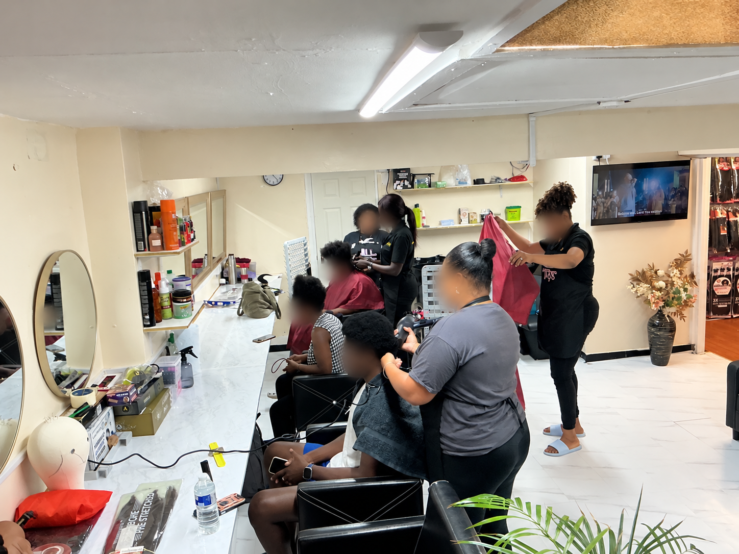 The team working in the salon, faces blurred