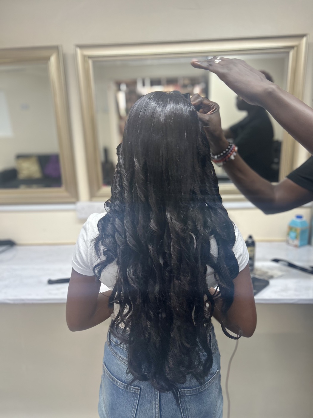 Wig installation with long styled curls, photographed from the back